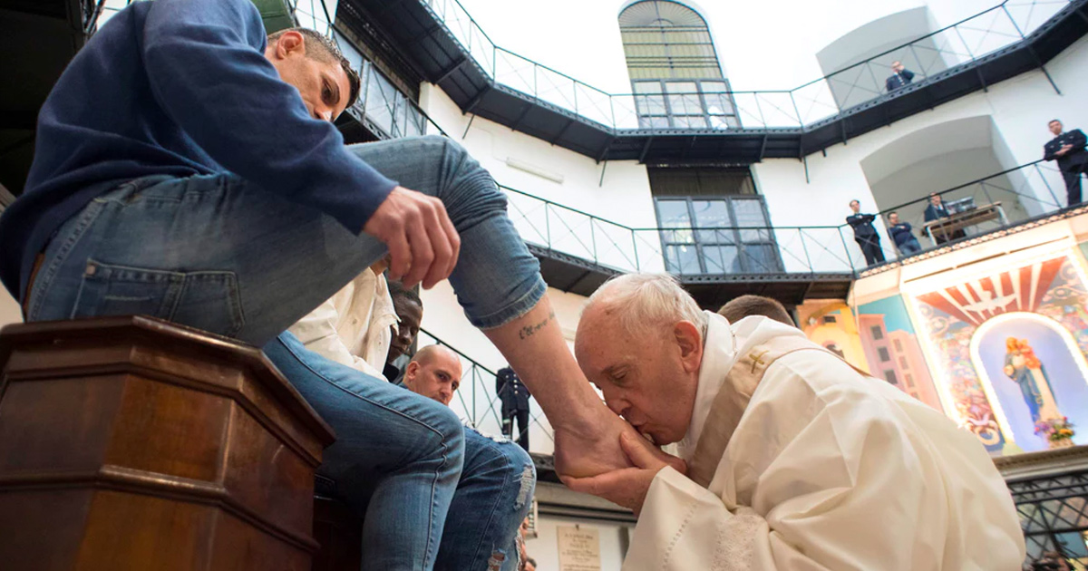 Pope Francis kisses the foot of an inmate during Holy Thursday Mass on March 29, 2018 at Regina Coeli prison in Rome